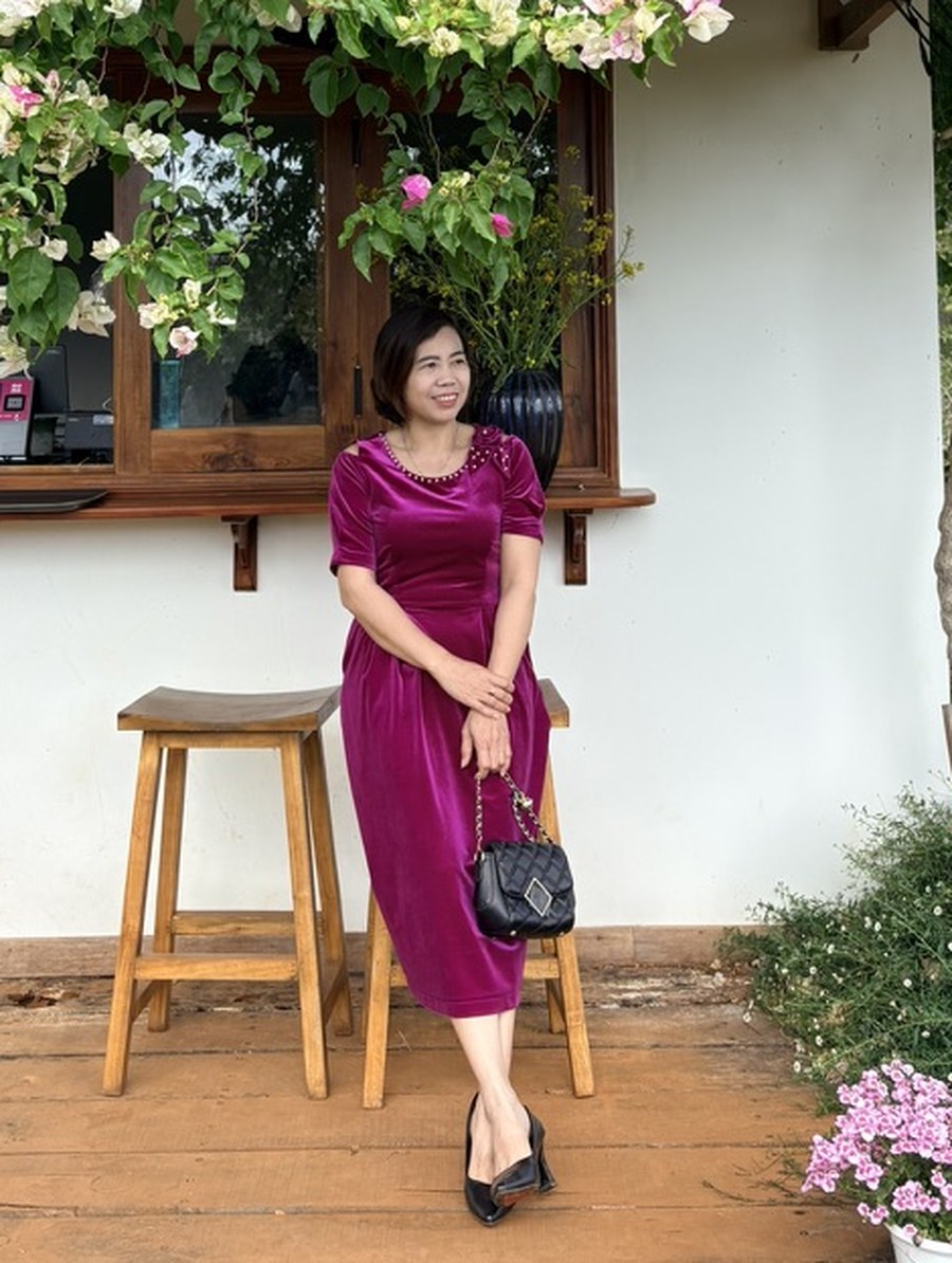 Kiều Oanh đứng dưới giàn hoa giấy trước hiên nhà
